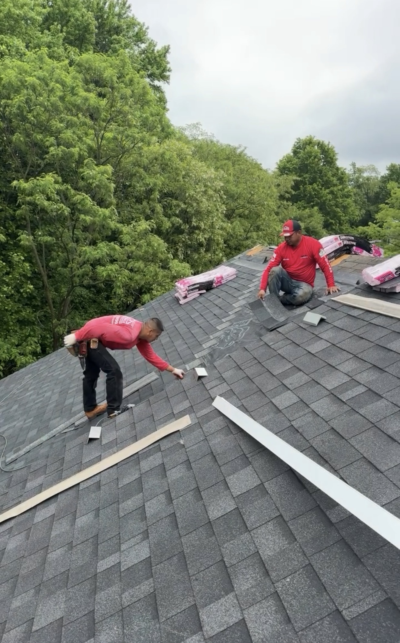 Roofing crew installing shingles